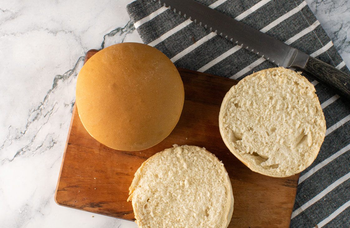 Pão de hambúrguer União cortado sobre tábua